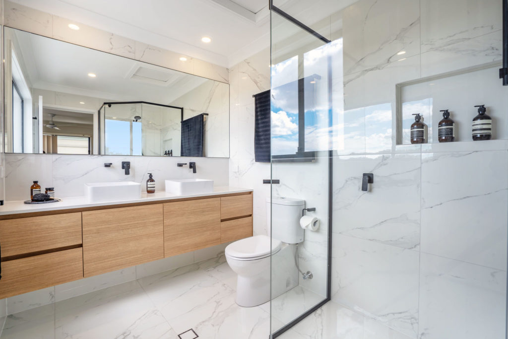 new ensuite bathroom with, marble look tiles, wooden vanity, double sink, black fittings, large mirror